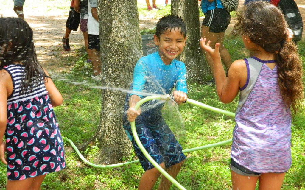 Kids playing with a water hose