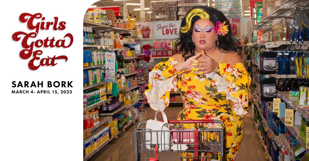 An image of a person in drag shopping at the grocery store with the text 'Girls Gotta Eat Sarah Bork March 4 - April 13, 2023'