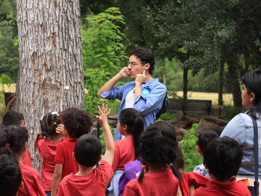 Students from Graham Elementary School listen to an instructor on a Peasecology School Field Trip in Pease Park.