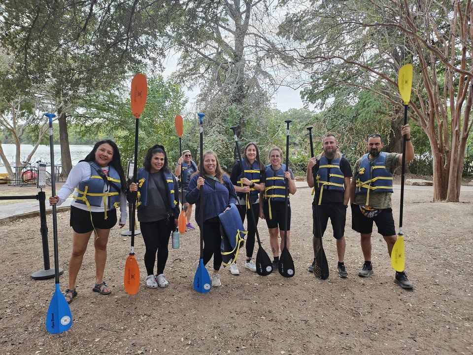 kayakers posing for a photo with oars and life jackets