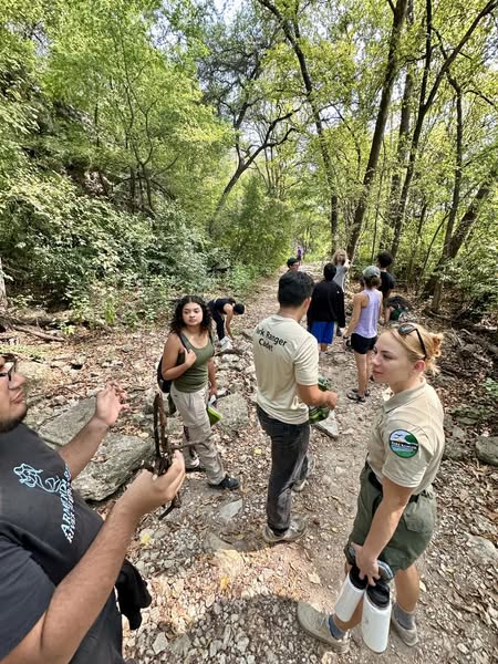 Group of teen students on a forest hiking trail with Ranger Leader.