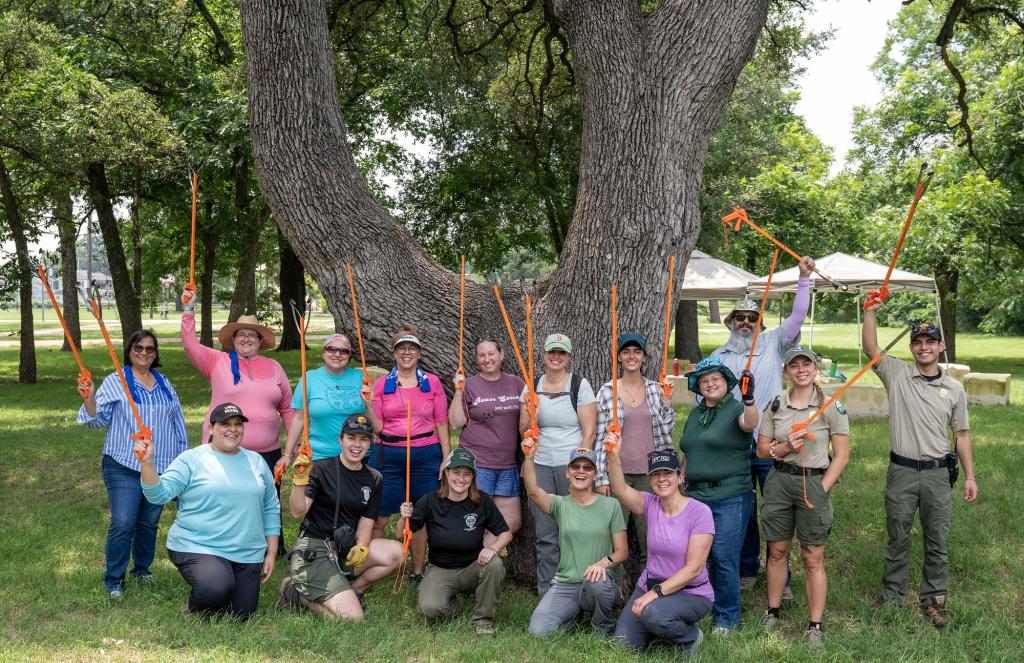 Groups of volunteers with Rangers outside holding Trash grabbers.