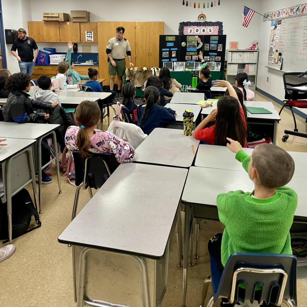 Ranger in the front of a classroom of kids.