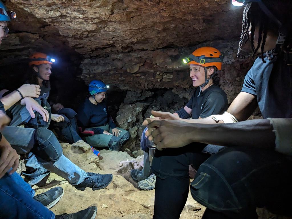 Rangers with people smiling with headlamps in a cave
