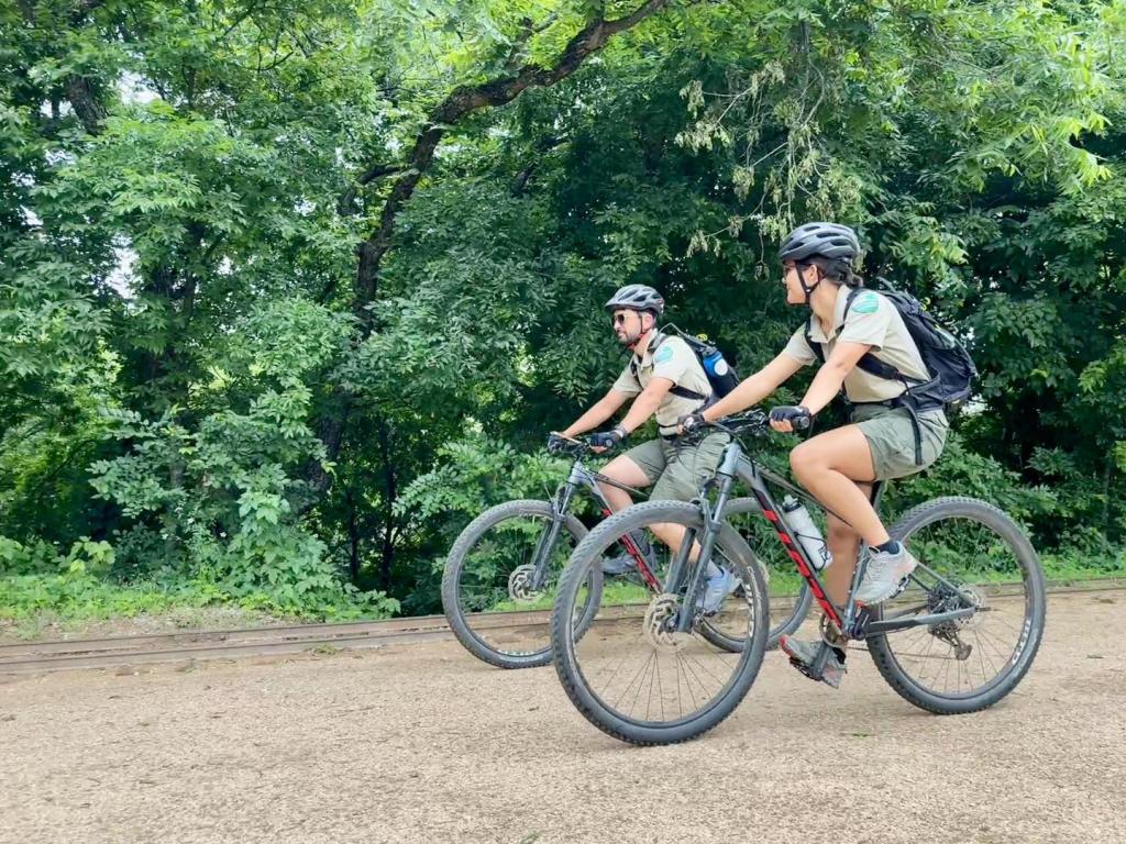 Rangers Biking on a train with green foliage in the background
