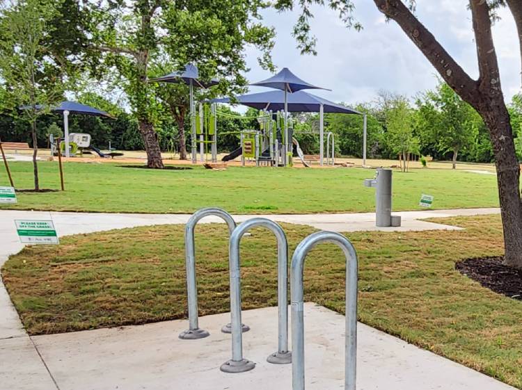 Photo of finished playground, water fountain, bike rack, and sidewalks at Earl. J. Pomerleau Pocket Park
