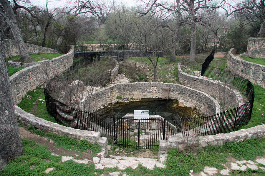 Photo of the Sunken Gardens, a small, spring-fed natural pool that is enclosed by rows of circular stone walls