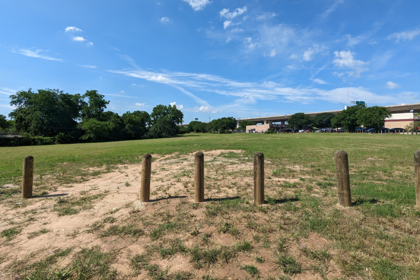 Photo of current conditions at Jamestown Neighborhood Park, an open field with wooden bollards.