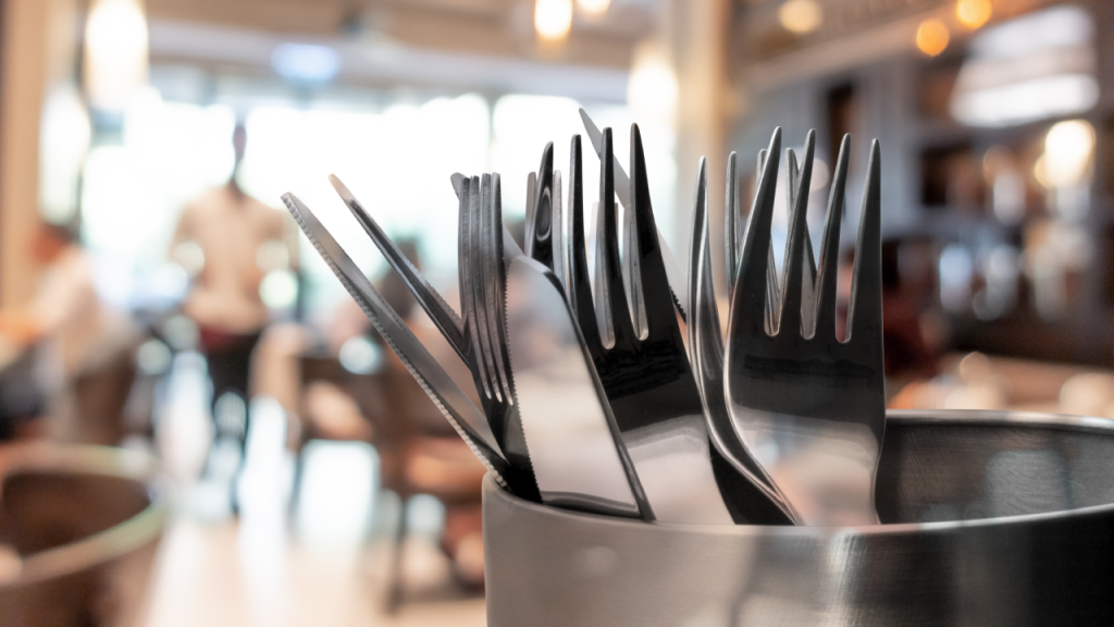 Silverware in a container at a restaurant.