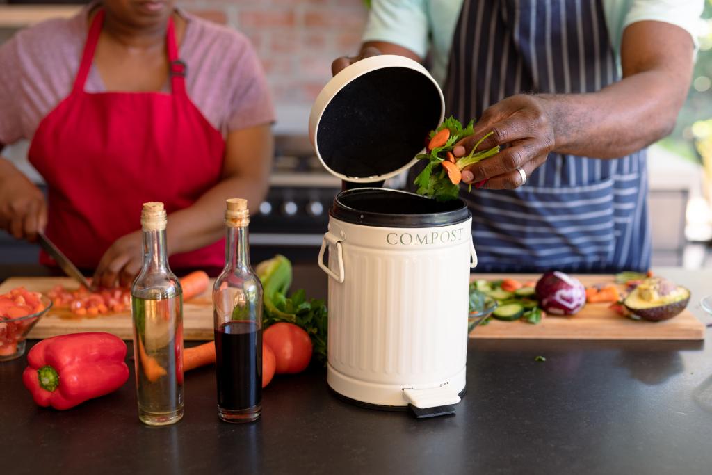 A kitchen counter with a compost collector for food scraps.
