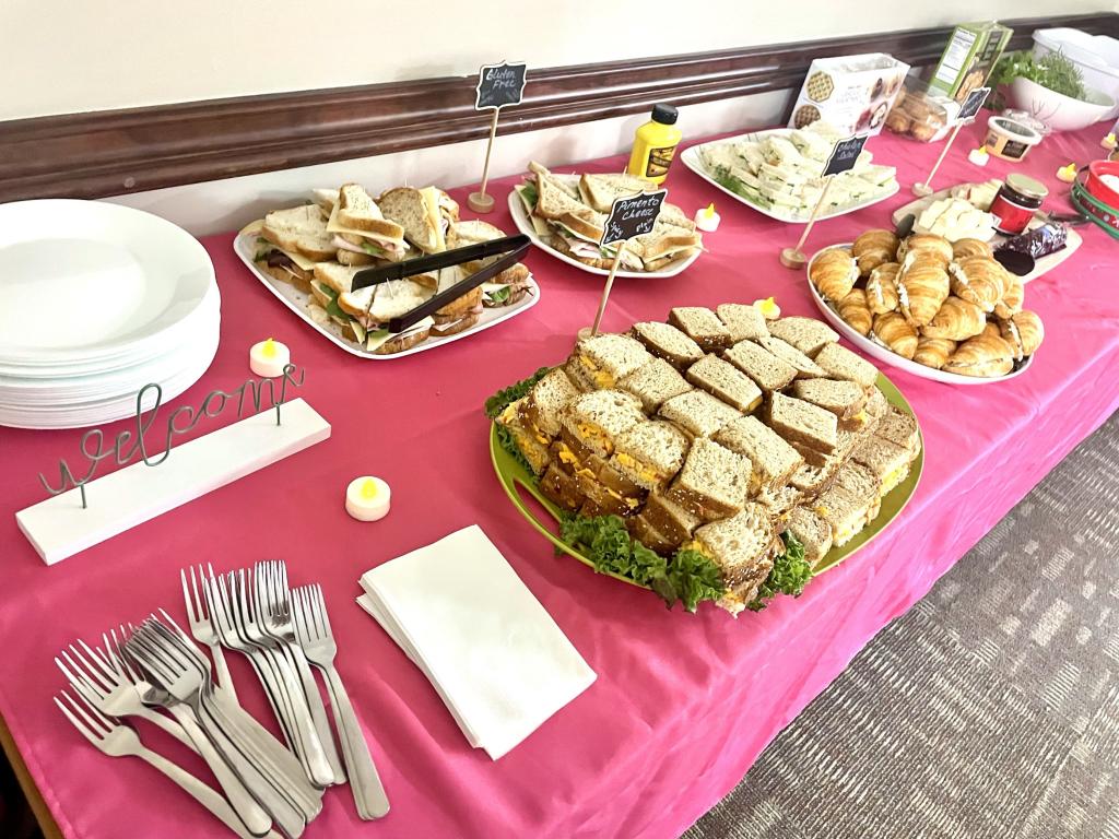 Party spread of sandwiches on table with reusable dishware.