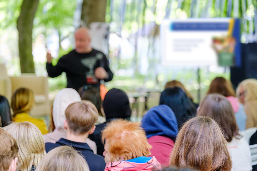 Audience watches presenter at a public event.