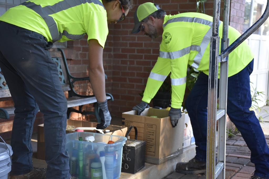 Austin Resource Recovery employees collect Household Hazardous Waste from the porch of a resident that used the on-demand collection service.