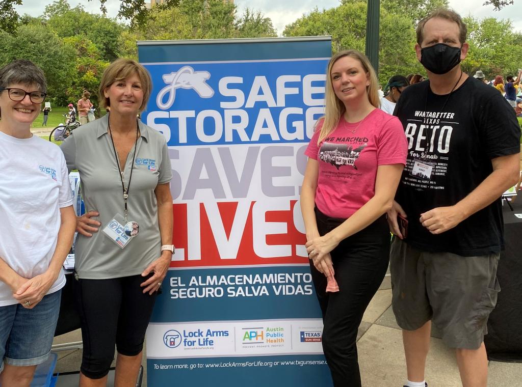 community members next to sign that says Safe Storage Saves Lives