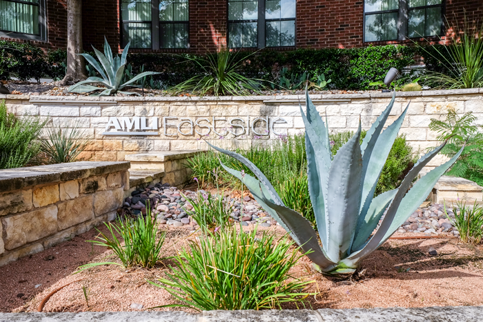 AAMLI Eastside signage with plants in front.