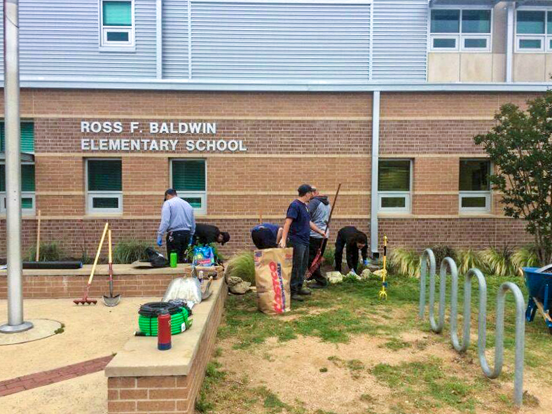 Firefighters working on building a garden in front of Ross F. Baldwin Elementary School.