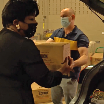 Photograph of Angela Medearis pulling boxes of food from the trunk of a car.