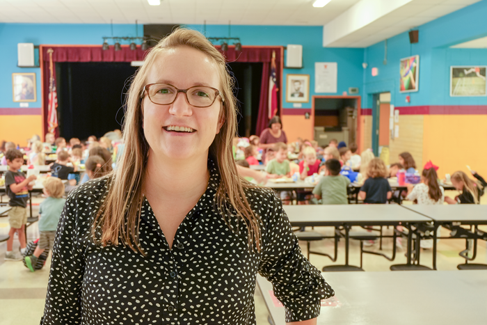 Anneliese in a school cafeteria. She is smiling at the camera.