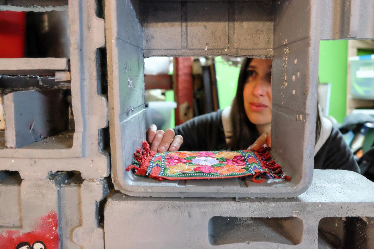 Caroline placing a rug in a tiny city made of styrofoam.