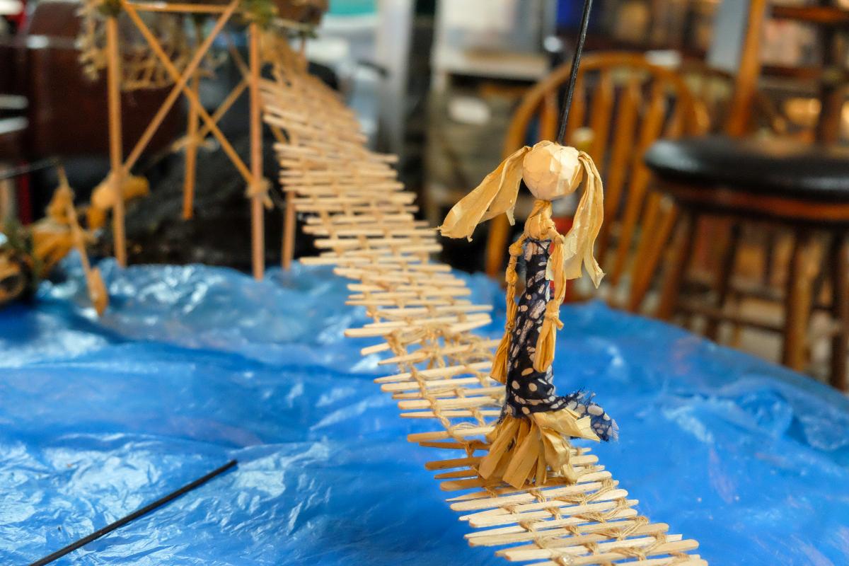A puppet on a stick bridge over a plastic ocean.