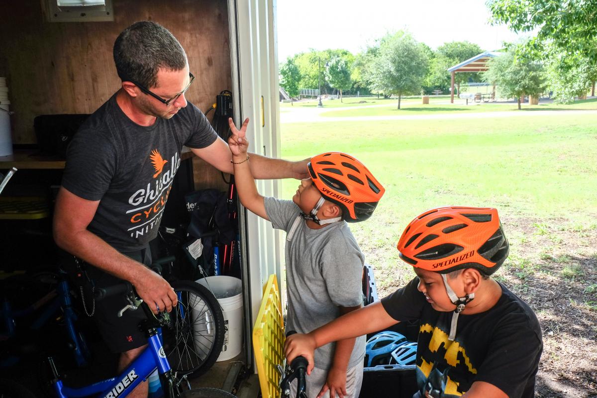 Chris Stanton shows kids how to properly fit helmets.