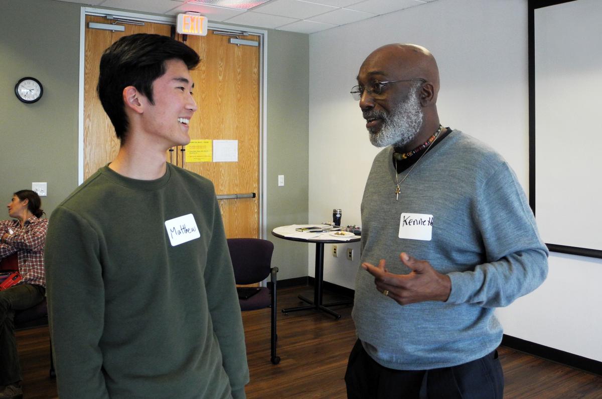 Two people talking to eachother in a conference room.