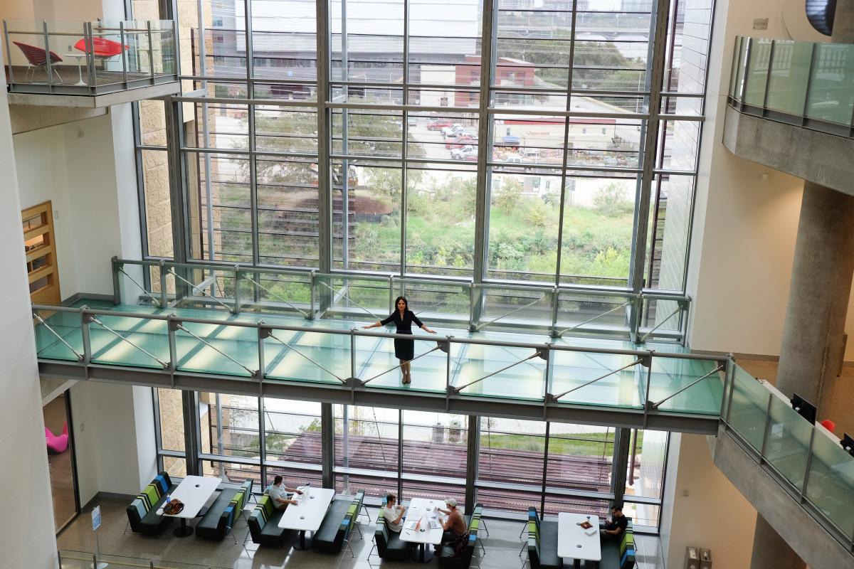 Heidi standing in the new Central Library atrium with lots of natural light and glass panels behind her.