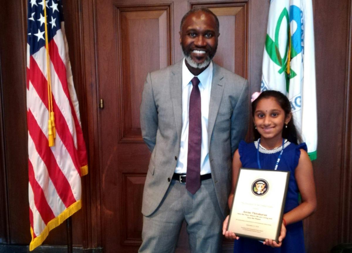 Asvini standing with an official holding award.