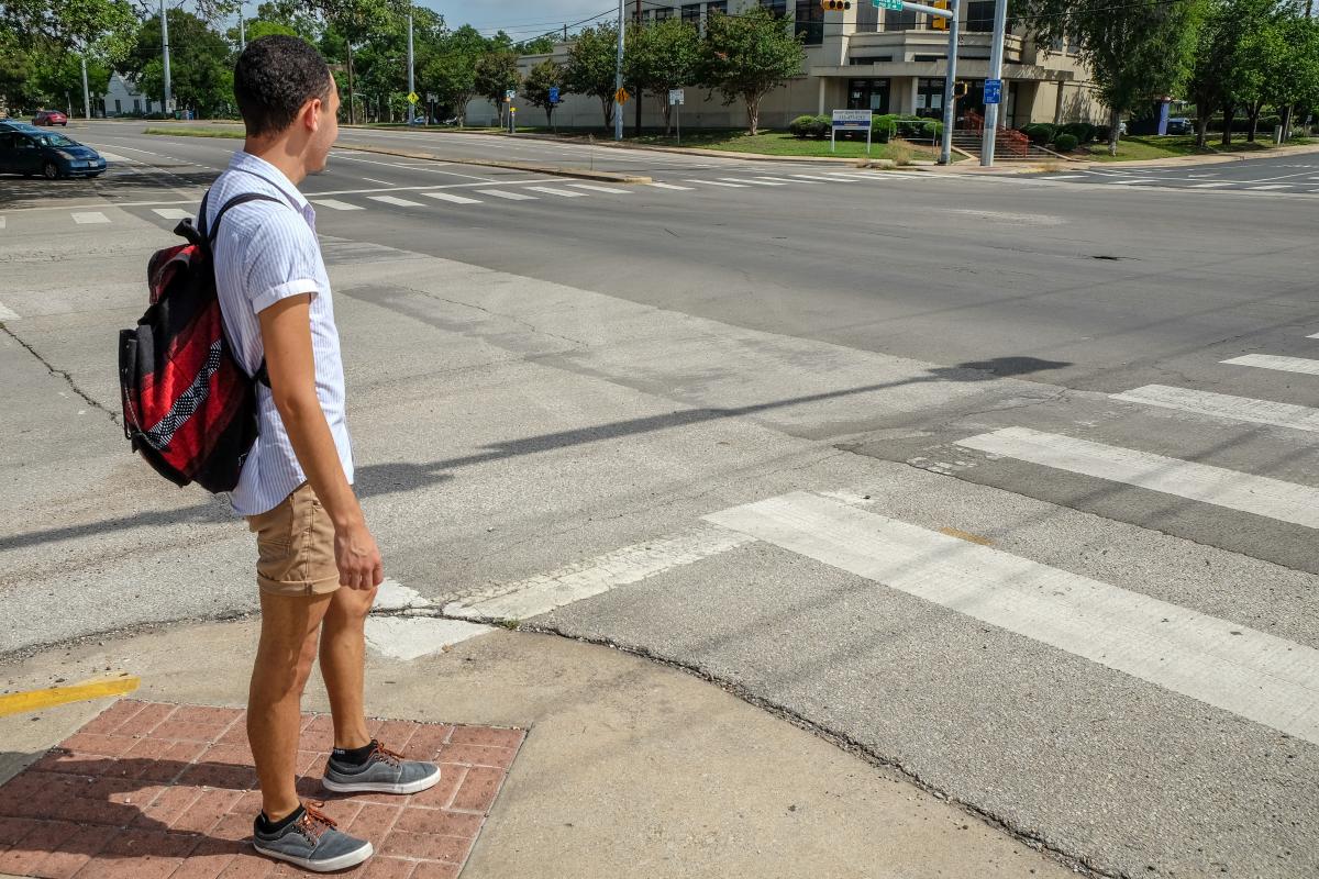 Juan waiting to cross an intersection.