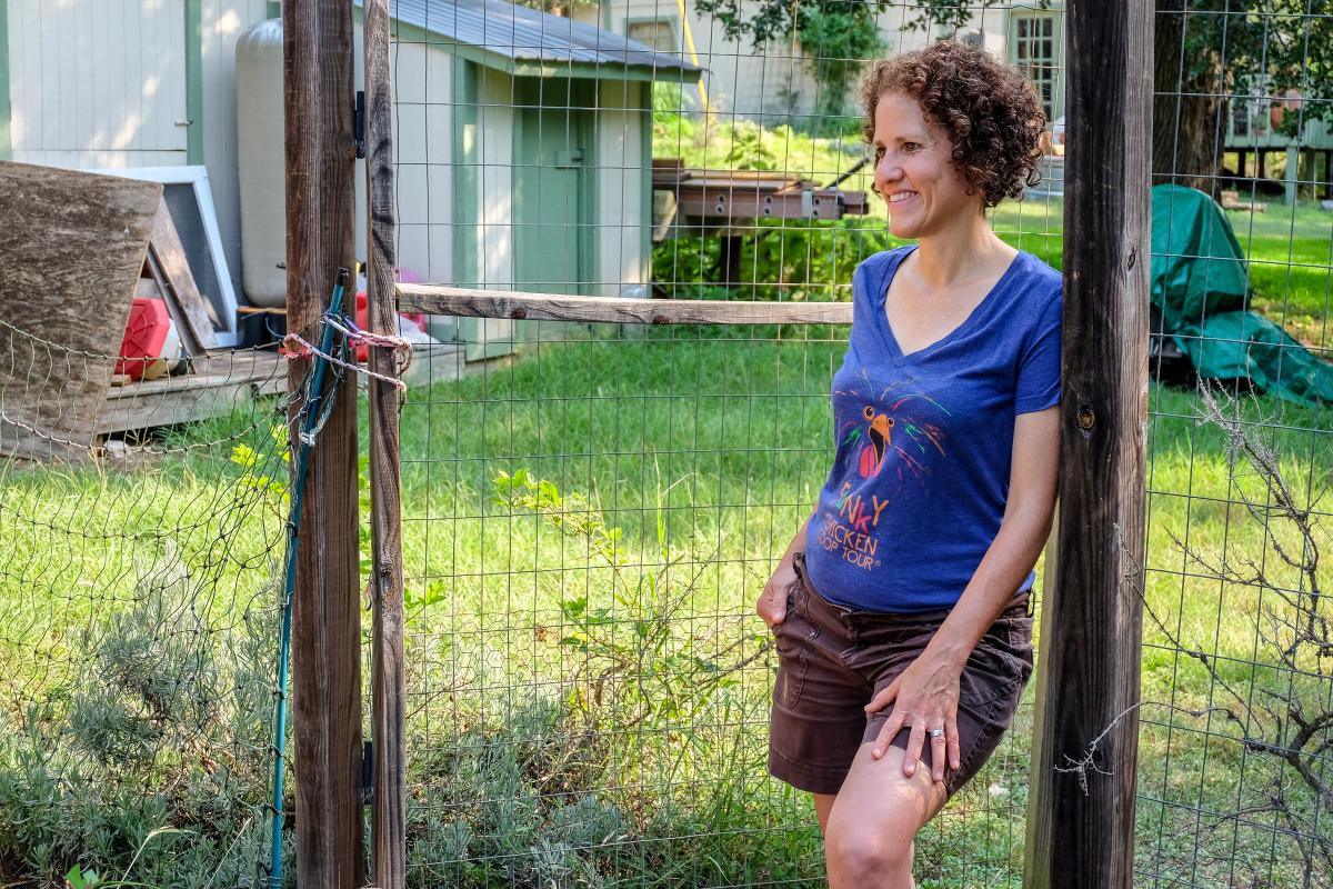 Michelle standing against a fence.