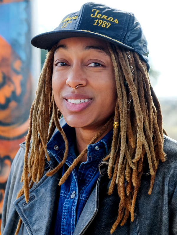 Headshot of Raasin McIntosh wearing a black hat that says "Texas 1989"