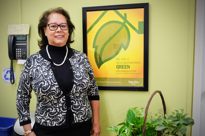 Rosa pictured in front of BCL's recycling and composting station in their break room.