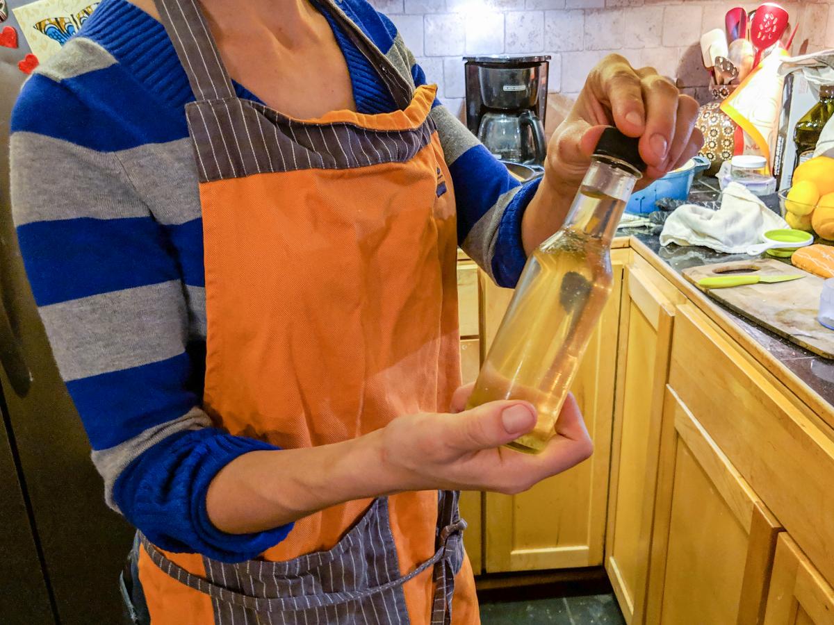 Rosie holding a bottle of citrus-infused simple syrup.