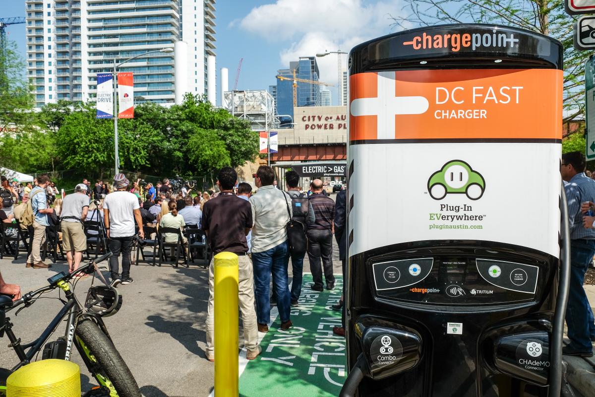 DC fast charger with people at the event in the background