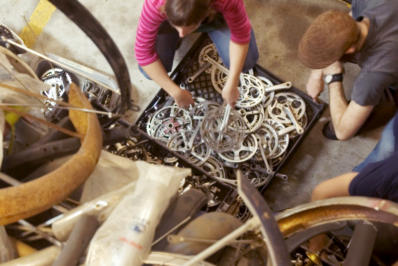 Volunteers sorting through bicycle wheel parts.