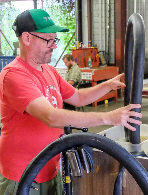 Person cleaning and checking a bicycle tube for air leaks.