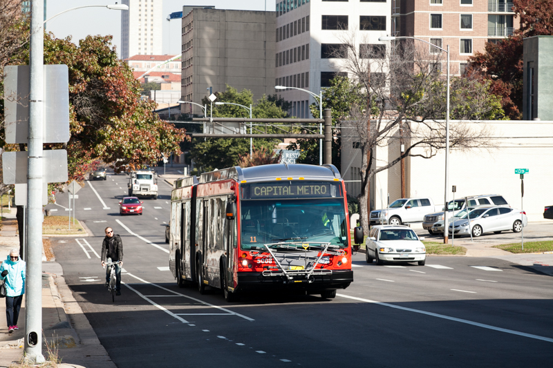 Photo of a person riding a bike next to a bus.