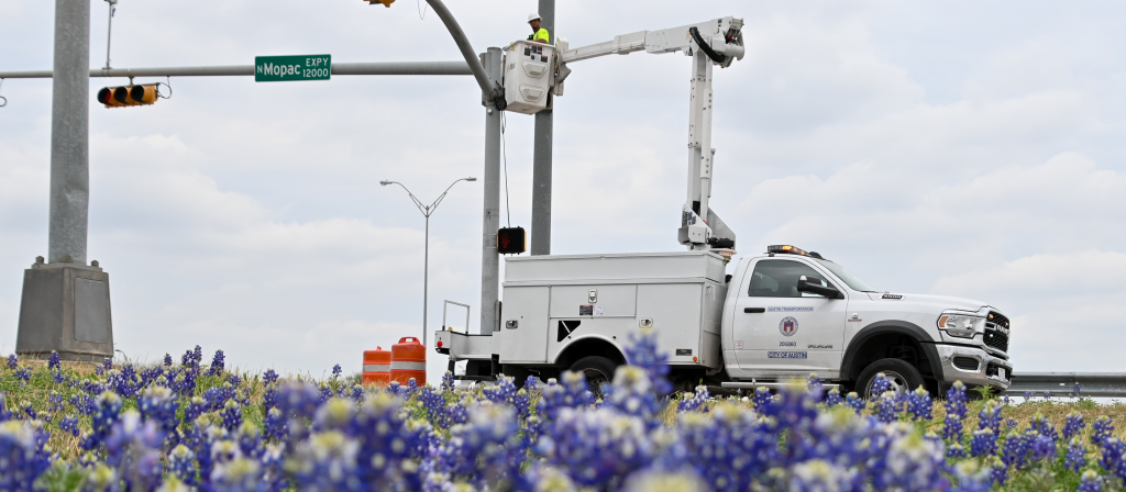 A traffic signals technician repairs equipment at MoPac Service Road and Duval Road.