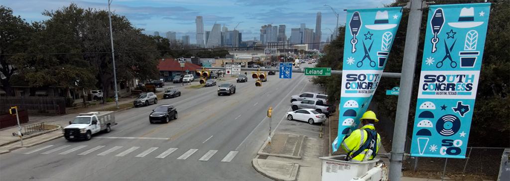 Austin Transportation crew installs lamppost banner on South Congress Avenue.