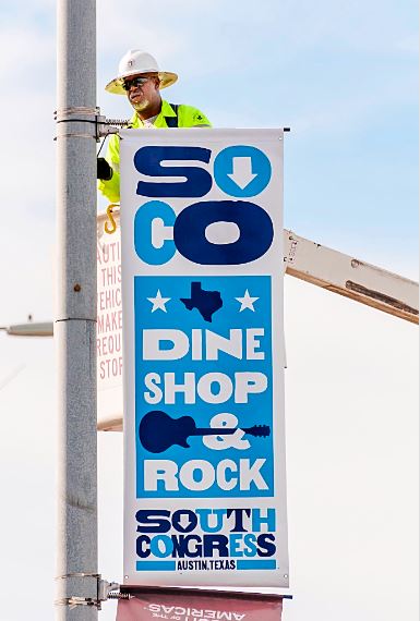 ATD employee installs banner in south congess