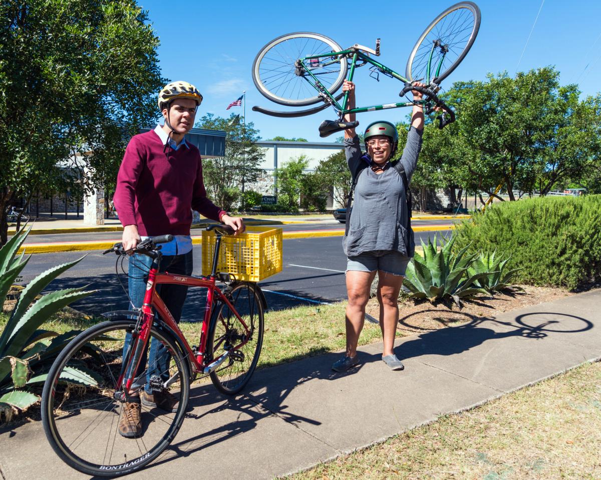 Cyclists standing on sidewalk with their bikes