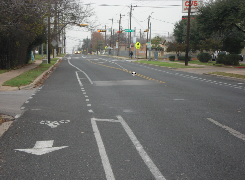 A photo of Berkman Drive with two vehicle lanes, a left-turn lane and a bicycle lane.