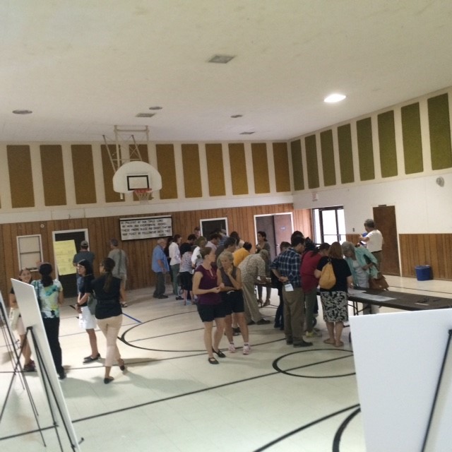 A gymnasium filled with people and presentation materials.