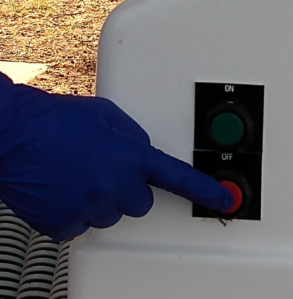 hand pressing the red off button the pump system