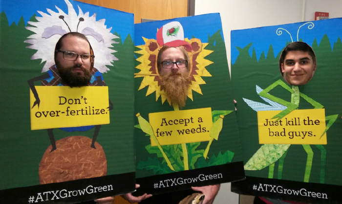 The Big Three. Three posters being held by three men: Don't over-fertilize. Accept a few weeds. Just kill the bad guys.