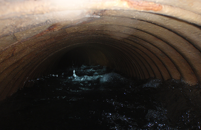 The spring water moving through the buried pipe.