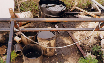 Dead grass and cotaminated soil caused by a gasoline spill at a residence.