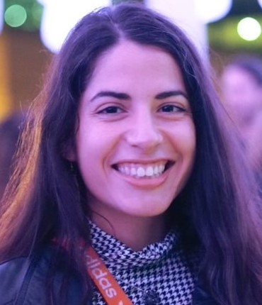A person smiling with loose straight hair framing their face
