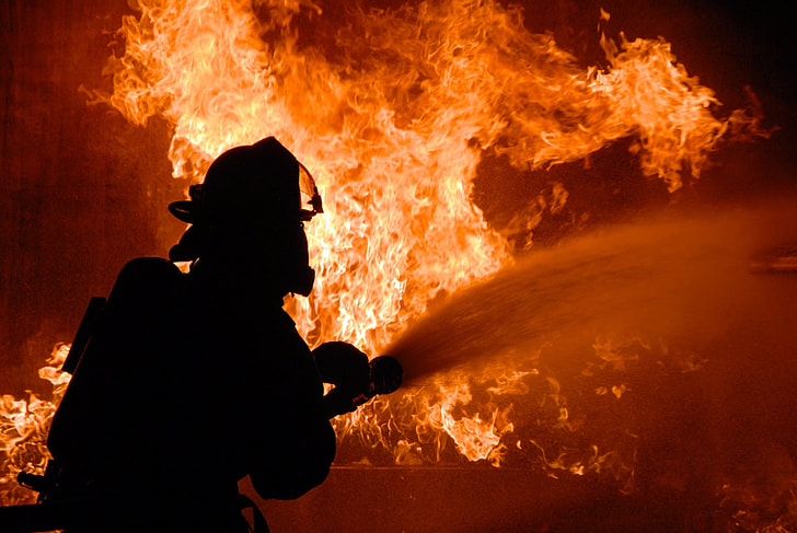 Fireman fighting raging orange flames