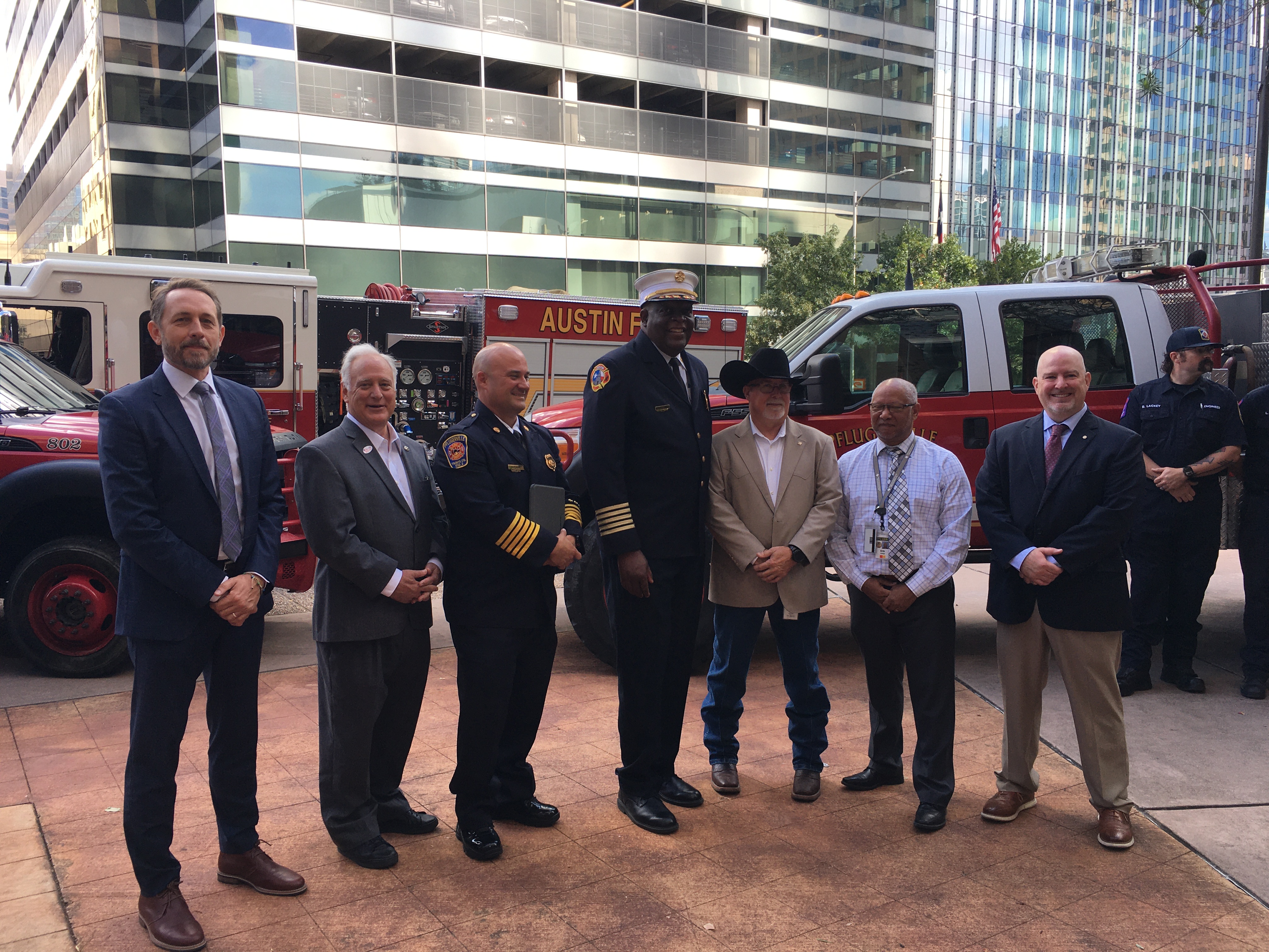 Group of city and county officials stand together for a photo following a press conference about wildfire threat and preparedness.